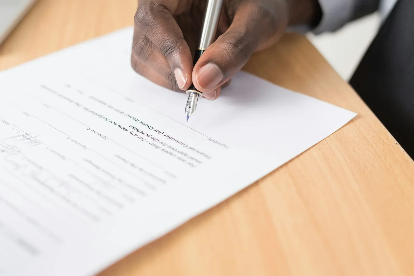 Persona completando un documento sobre un escritorio