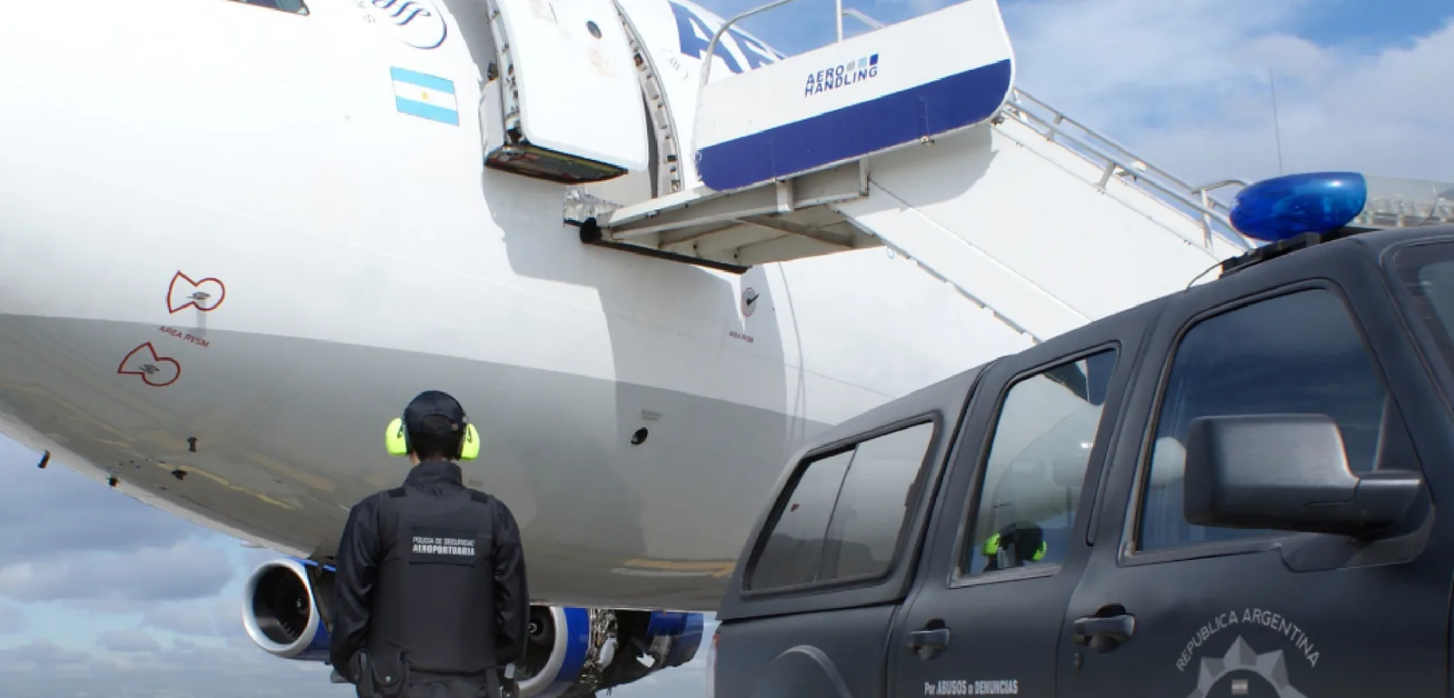 Personal de la Policía de Seguridad Aeroportuaria junto a un avión